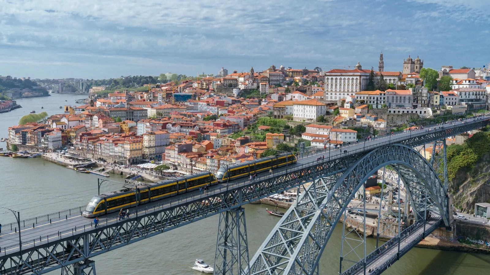 A tram crossing the upper deck of the Luis I Bridge over the Douro River in Porto