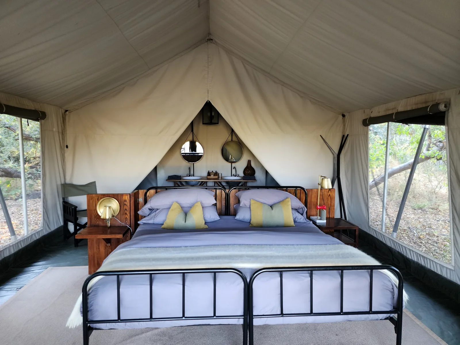 Inside a tented safari camp in Botswana, canvas walls open to the bush
