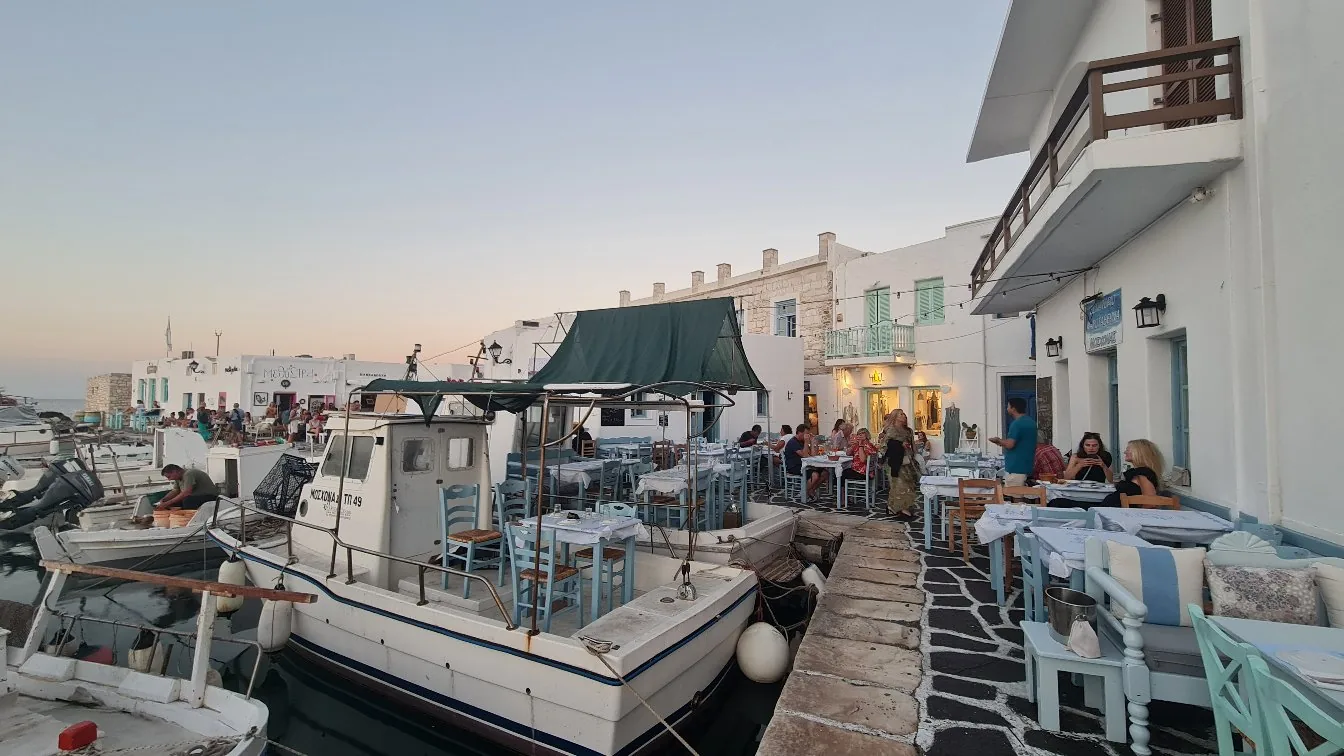 Fishing boats moored beside waterfront tavernas at dusk, Paros