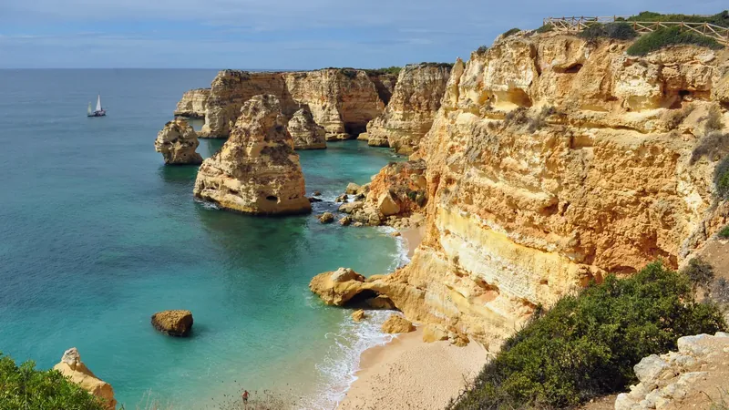 Limestone cliffs and sea stacks above the small beach at Praia da Marinha, Algarve, with turquoise water below